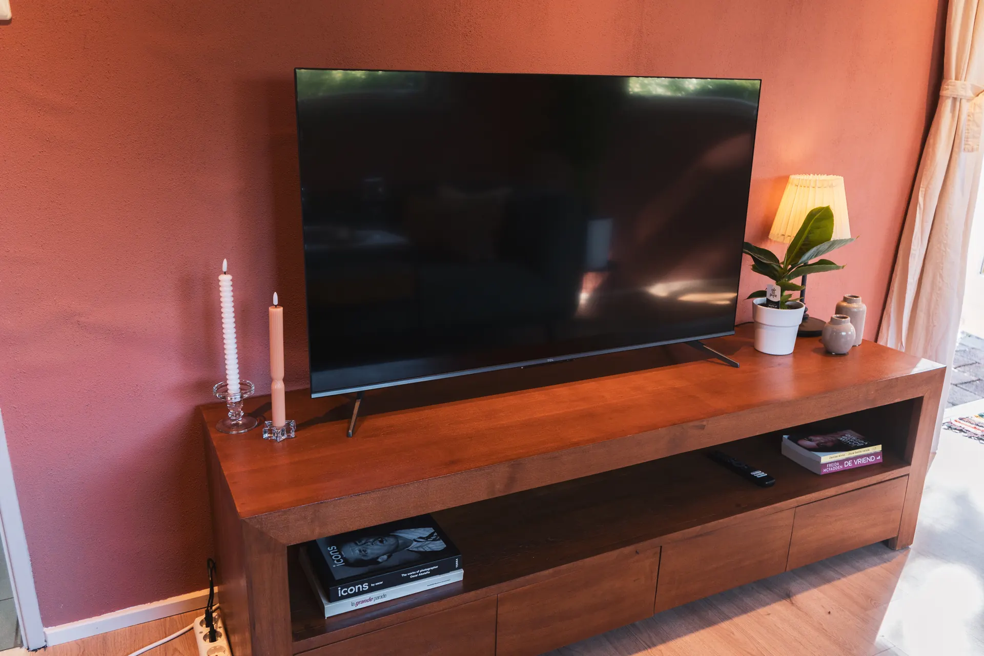 Smart-tv op houten tv-meubel in de woonkamer van Huisje Pip
