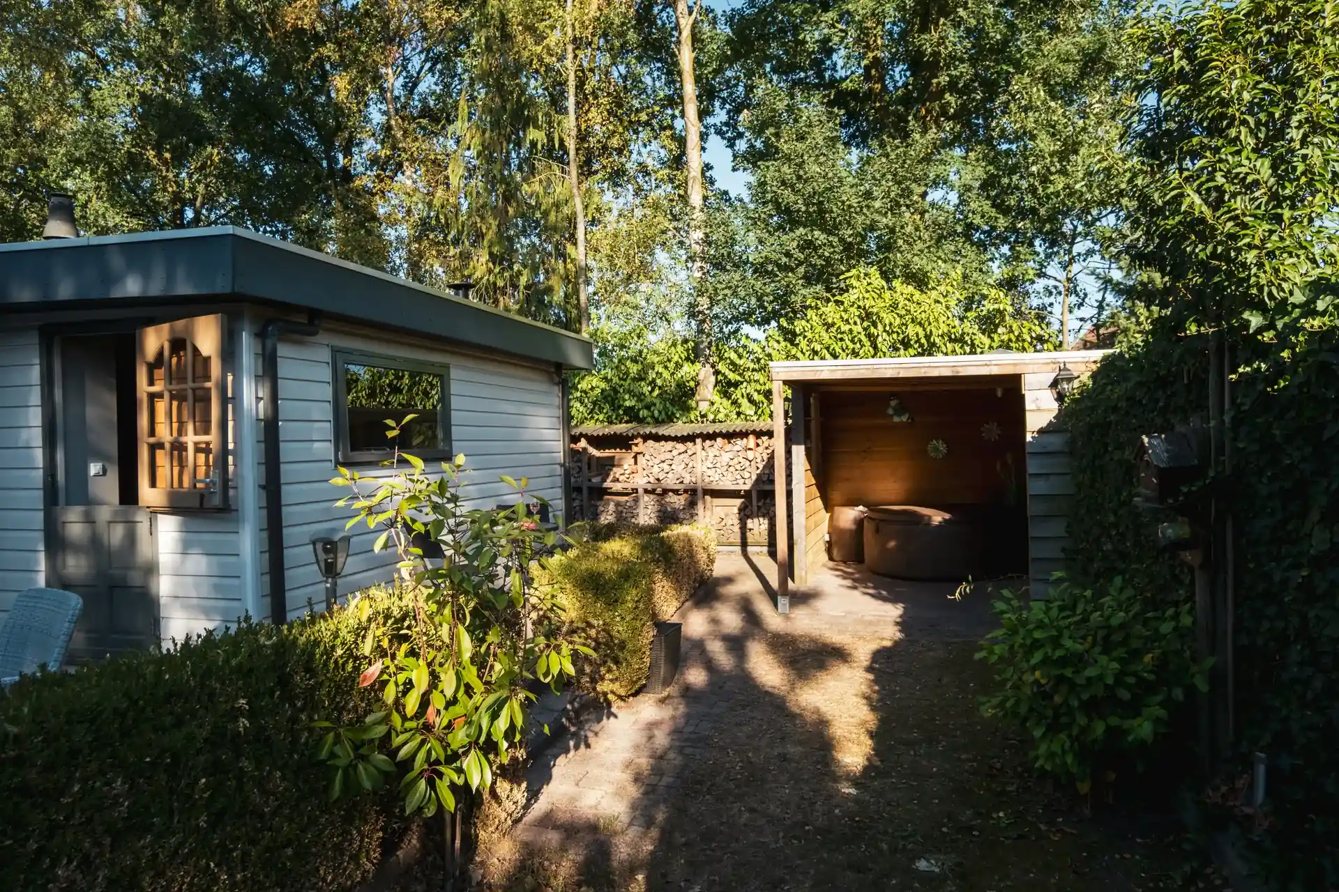 Privé tuin van Huisje Pip met hoge bomen, Putten op de Veluwe